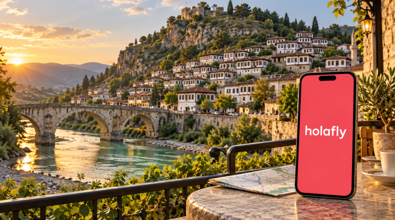 Teléfono con Holafly en pantalla ante las casas históricas y el río de Berat